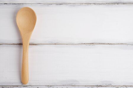 Wood spoon and napkin close up on wood white table background, vintage style.の写真素材