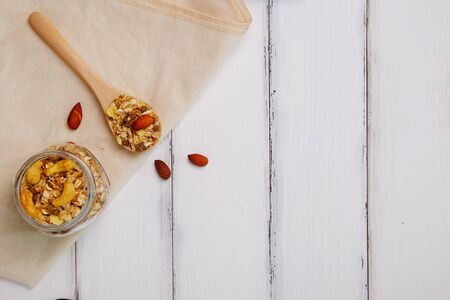 Healthy food top view of muesli isolated dried food and nut on white wood table background, decorated spoon and napkin concept.の写真素材