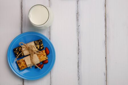 Healthy homemade grain bar and milk on white wood table background style, top view.の写真素材