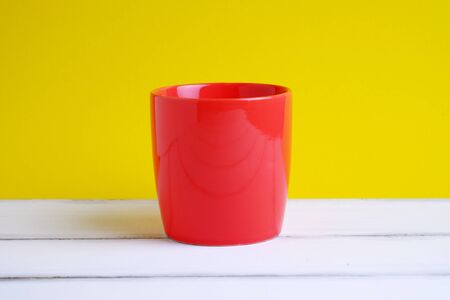 Close up of one red cup on wood table and yellow  backgroung concept.の写真素材