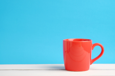 Close up of one red cup on white wood table and blue background concept, with blank space.の写真素材