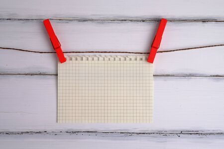 Blank white of paper with wood clip on white wood background design, vintage and close up.の写真素材