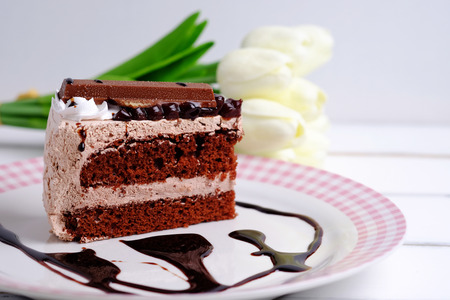 Close up of chocolate cake on plate on white wooden table background. Selective focus and decorated.の写真素材