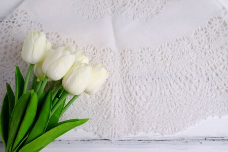 Top view of tulips and napkin on white wood background with blank space.の写真素材