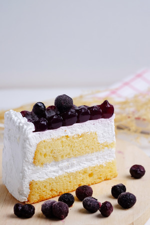 Close up of Blueberry cake on wood plate on table background. Selective focus and decorated.の写真素材