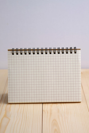 Close up of blank with notebook on wooden table and white background concept.