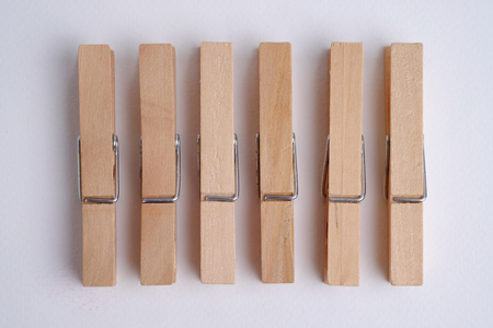 Set of wooden cloths pins on white background.