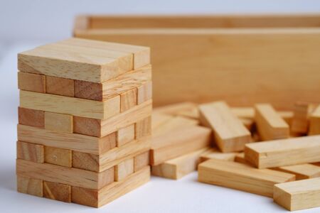 Wooden block tower game for children and business concept on white background, close up and...