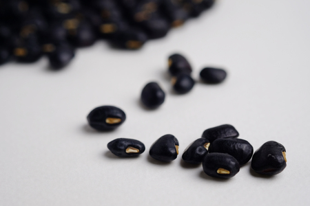 A lot of black beans on white background, close up, selective focuus and blank space.の写真素材