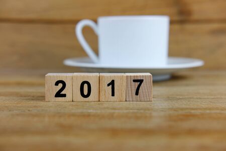 Happy new year 2017 on wood table background concept, decoration with coffee cup, close up and selective focus.の写真素材