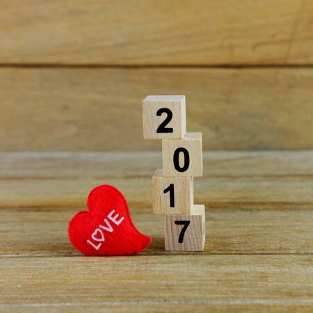 Happy new year 2017 on wood table background concept, decoration with red heart, close up and...