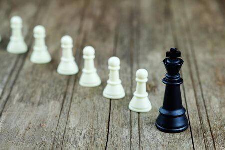 Close up of chess with black king on wood background concept. Business concept able to survive or...