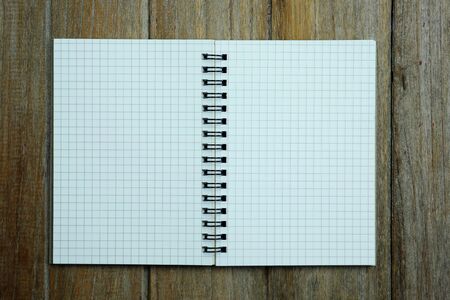 Blank open notebook on wood table background concept, top view.