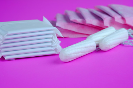 Woman hygiene protection of cotton tampons and sanitary pad on pink background, woman menstruation cycle, critical day, selective focus and copy space.の写真素材