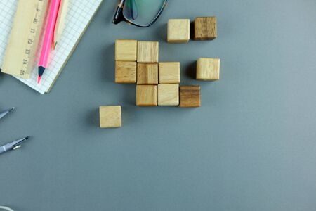Office desk wooden table with wood block, notebook and decoration on gray background. Business planning concept, copy space, selective focus.の写真素材