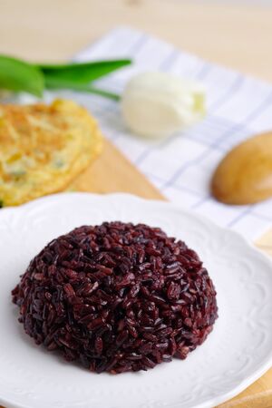 Close up of healthy eating with Rice berry in white plate on napkin and wooden concept. Selective focus and clean food style.の写真素材