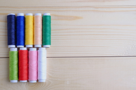 Vintage background with colorful thread and sewing kit for needlework on wooden background. Blank...