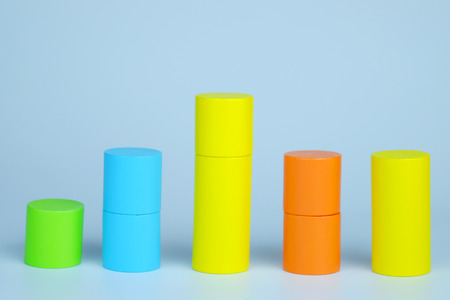 Close up of wood cylinders with representing a graph on gray background. Business growth concept and copy space.の写真素材