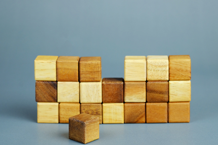 One piece of cube wood block missing, symbolizing to business concept of uncomplete, need to fit, solving problem, last piece of solution, selective focus.の写真素材