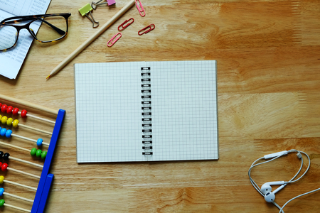 Blank open notebook with abacus, glasses, pen and decoration on wood table background, copy space, business and education concept.の写真素材