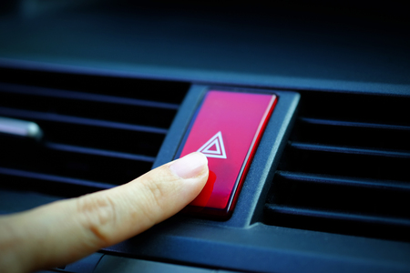 Close up of Finger pressing emergency button in car, selective focus and vignette effect design.の写真素材