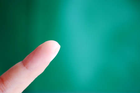 Female finger on green background concept and copy space.の写真素材