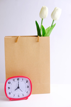 Brown paper bag isolated with shopping concept on gray background. Blank space, close up, decorated clock and tulip style.の写真素材