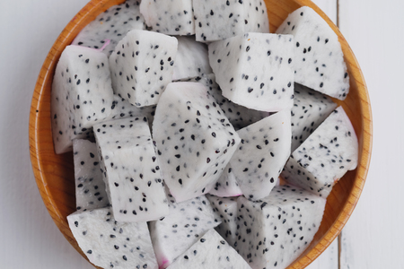 Top view of dragon fruit isolated in wood cup  concept on white wooden table background. Selective focus and decorated.の写真素材