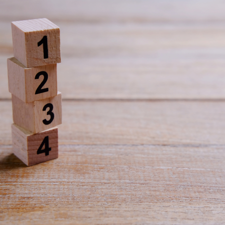 Cloce up of alphabet 1 2 3 and 4 building wooden block on wood background. Business conept of shoeing advanced and business vision. Selective focus, empty and blank space for text concept.の写真素材