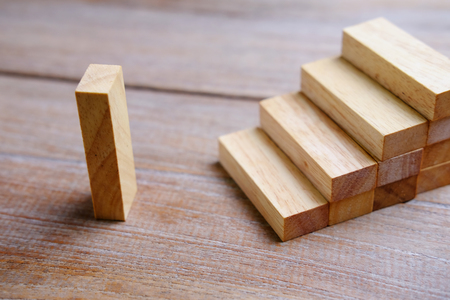 Wood block step stair of pyramid on wood background. Business concept for growth success process. Selective focus on the top step, blank space for your text or design.の写真素材