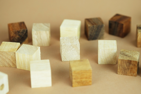 One wooden block standing from other standing in row on brownbackground. Business concept metaphor to leadership for survive. Selective focus dominant wooden block.の写真素材