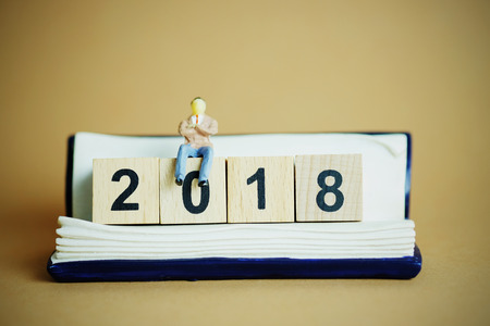 Close up of Happy new year with Businessman miniature figure toy sit on stack of number 2018の写真素材