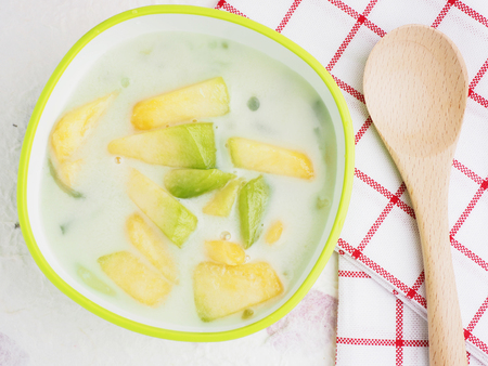 Cantaloupe with coconut milk dessert, Thailand candy and white background, top view, decorated napkin and spoon.の写真素材