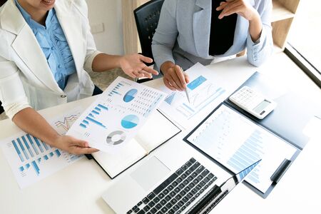 Two leader business women discussing the charts and graphs showing the results.の写真素材
