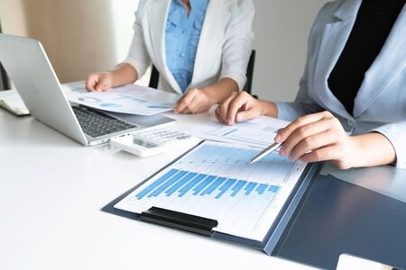 Two business leader women discussing the charts and graphs showing the results.の写真素材