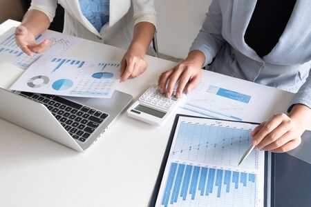 Two business leader women discussing the charts and graphs showing the results.の写真素材