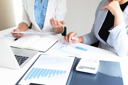 Two bussiness leader women discussing the charts and graphs showing the results.の写真素材