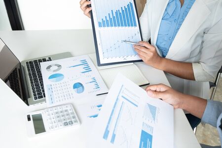 Two bussiness leader women discussing the charts and graphs showing the results.