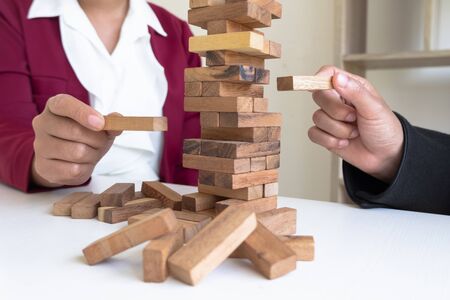 Image of hand holding blocks wood game to growing up of business. Risk of management and strategy plan.の写真素材