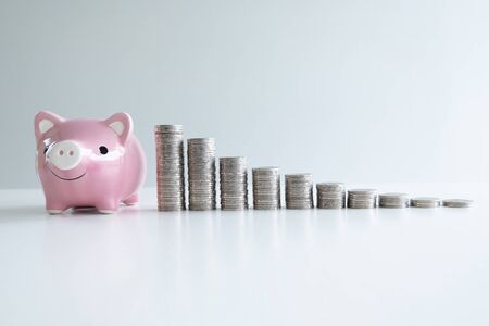 pink piggy bank saving money with coins bar graph, step up growing business to success and saving for retirement concept.の写真素材