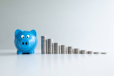 blue piggy bank saving money with coins bar graph, step up growing business to success and saving for retirement concept.の写真素材