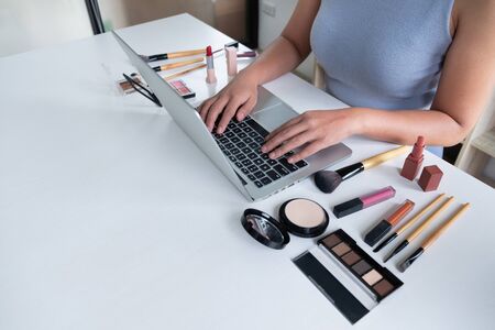 woman blogger present cosmetic product sitting in front tablet and broadcast to social network by internet, beauty blogger online marketing concept.の写真素材
