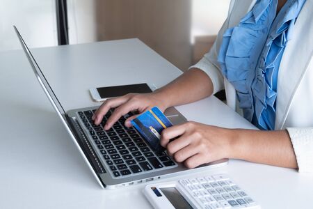 woman use credit card for online shopping on her laptop and phone.の写真素材