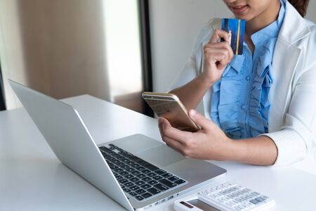 woman use credit card for online shopping on her laptop and phone.の写真素材