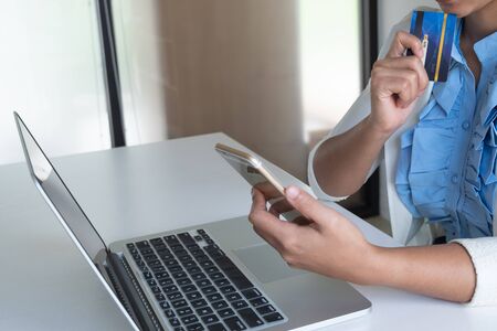woman use credit card for online shopping on her laptop and phone.の写真素材