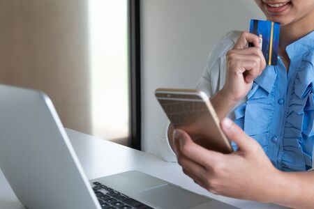 woman use credit card for online shopping on her laptop and phone.の写真素材