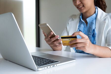 woman use credit card for online shopping on her laptop and phone.の写真素材