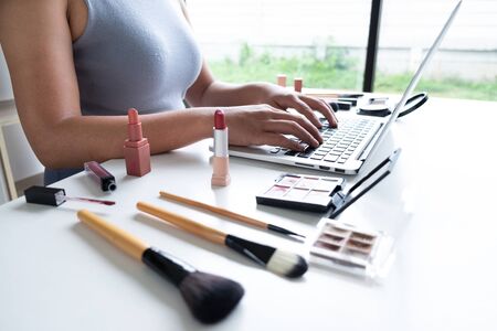 woman blogger present cosmetic product sitting in front tablet and broadcast to social network by internet, beauty blogger online marketing concept.の写真素材