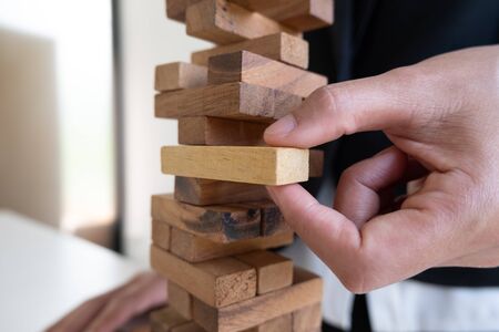 hand playing blocks wood game, gambling placing wooden block. Concept Risk of management and strategy plan, growth business success process.の写真素材