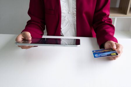 Business woman consumer holding credit card and tablet for online shopping and payment make a purchase on the Internet.の写真素材